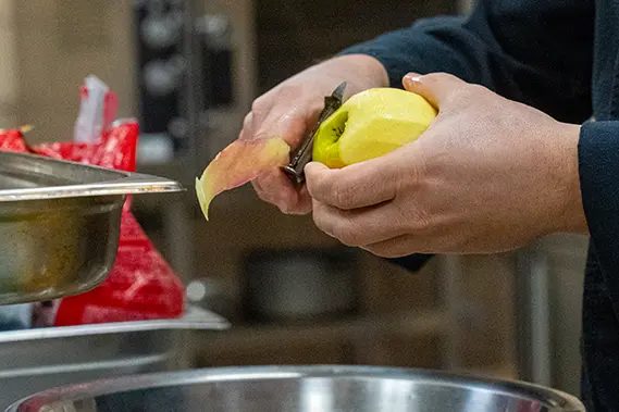 Un homme coupe une pomme dans un restaurant d'insertion local Café Fauve